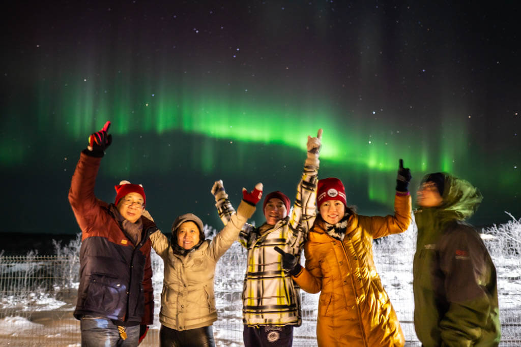 group photo under aurora borealis