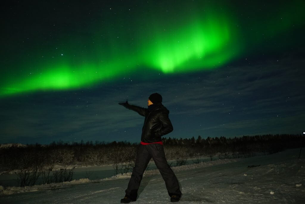 a guy under the dancing northern light