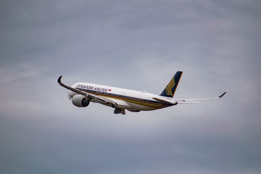singapore airline flying under grey cloud